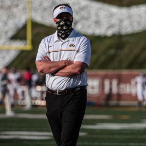 Photo of Missouri Tigers Coach Eli Drinkwitz on the field with Rock M in background.