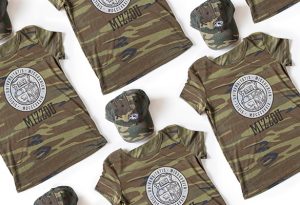 Photo of camo t-shirt and hat with "Mizzou" and spirit tiger head and UM seal.