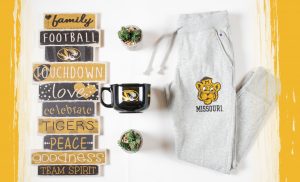 Photo of sweat pants, wall decoration and large mug with University of Missouri logos.